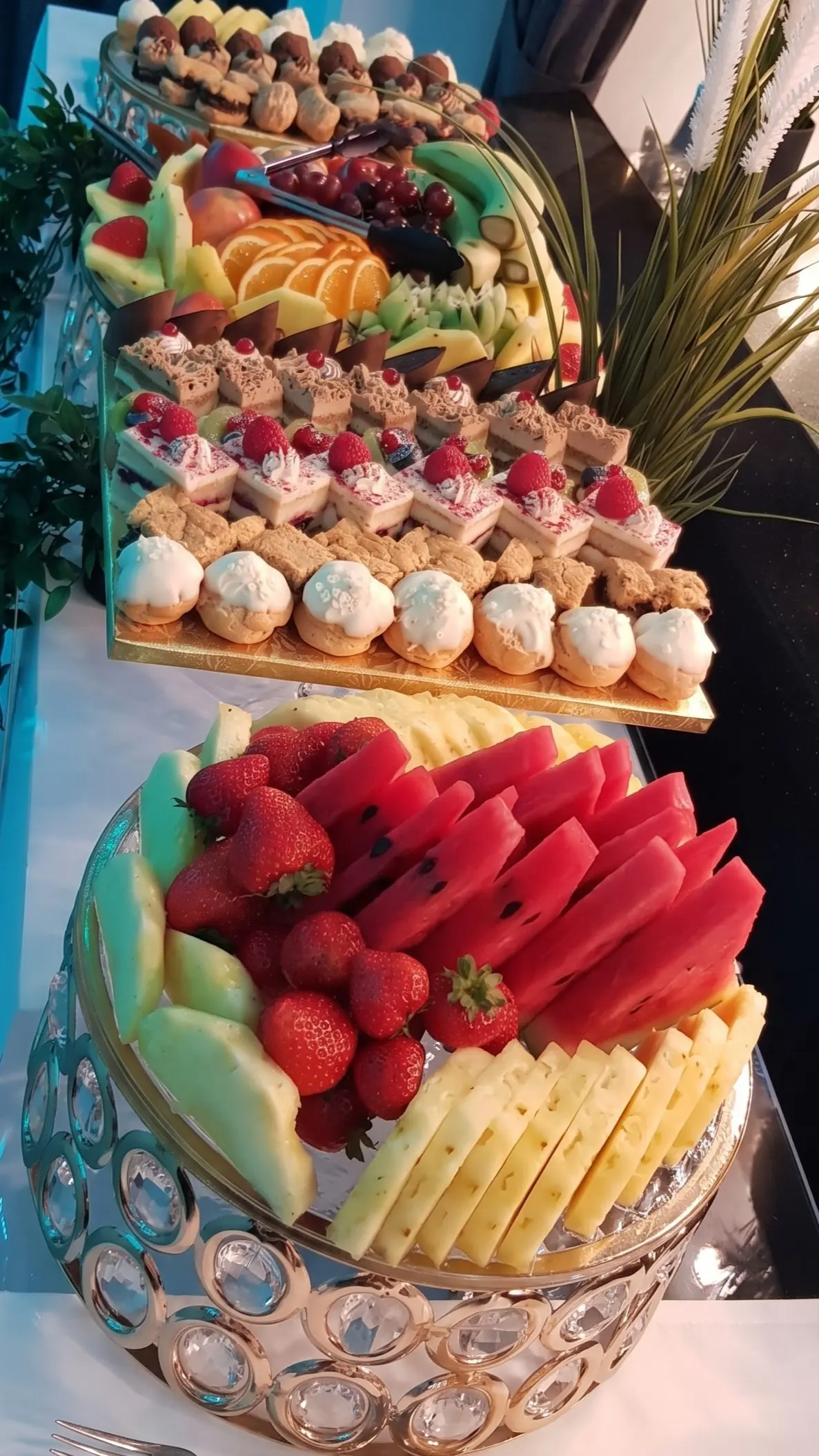 Dessert table display with fresh fruit, mini cakes, cream pastries and assorted sweet pieces